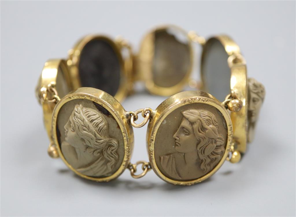 A Victorian gilt metal and lava bracelet, set with seven oval panels carved with busts of ladies and gentleman, 17.2cm.